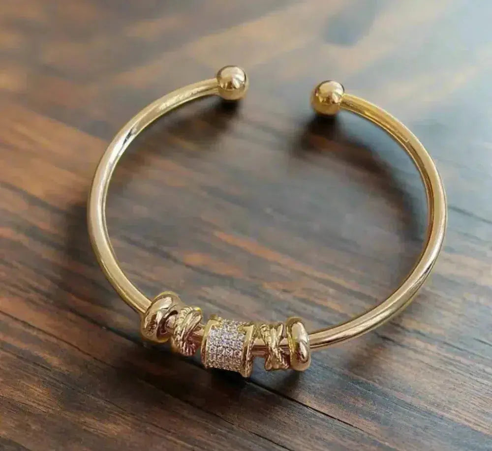 Justerbart armbånd med guldfarvede charms